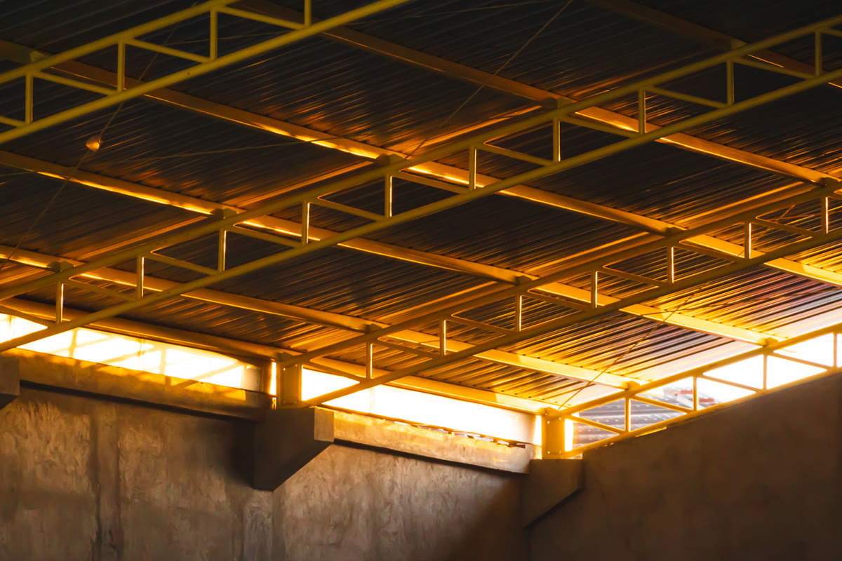Estructura metálica de cubierta iluminada en el interior de una nave construida por DCA